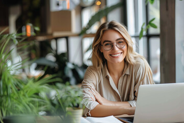 Happy girl student, young woman remote worker using laptop sitting at desk in cafee, university college campus classroom.
