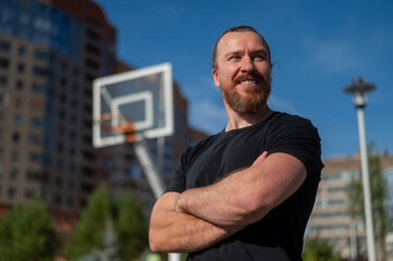 Portrait of a Caucasian bearded man on a basketball court outdoors. 