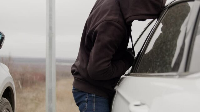 Car thief skillfully hacks into vehicle security system gaining access to car without fear. With adept manipulation thief overrides car's security initiating theft without raising suspicion presence.