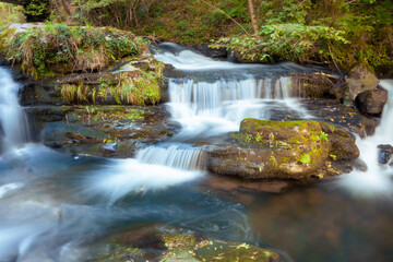 Small waterfall in the Pisueña river in autumn. Long exposure photography