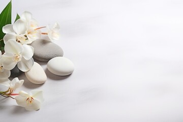 Fototapeta na wymiar Top view of white flowers with smooth pebbles. Copy space, spa concept