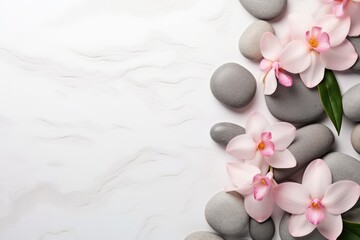 Fototapeta na wymiar Smooth stones, fresh flowers, and green leaves on a white marble background. Copy space, spa concept