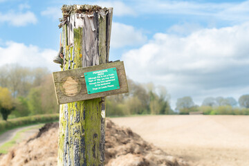 Old rustic Permissive path sign post showing the public that there is access to a foot path across agricultural farmland