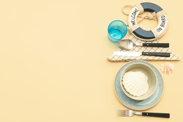 Beautiful table setting with seashells and lifebuoy on beige background