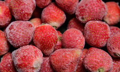 Close up photo of frozen fruits. Frozen strawberries background. Frozen strawberry with crystal of...