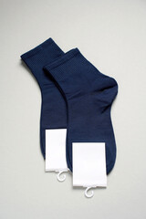 Mens new socks on a gray background, close-up. Cotton socks with blank label