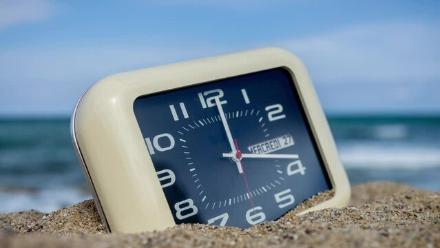 stopmotion of clock on a beach with sky and sea in background