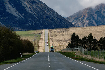 Long country road with cars driving on it at  Arthur's Pass, Canterbury, New Zealand.