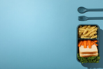 Blue lunch box with food on a blue background