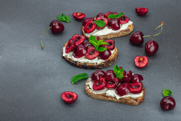 Fresh bread sandwiches with sweet cherry, cream cheese and mint leaves. Morning breakfast concept