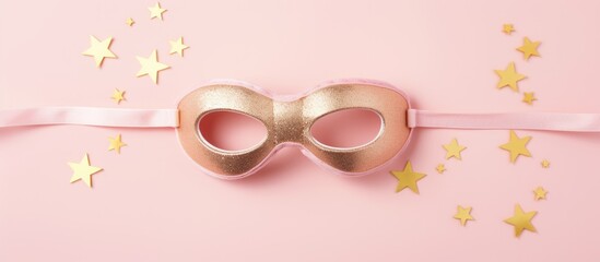 Naklejka premium Gold mask pink ribbon stars on pink background