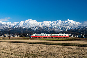 剱岳を眺めながら走る富山地方鉄道の電車