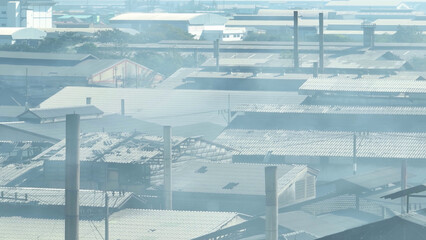 The drone's view exposes industrial estates emitting smoke, prompting us to address their environmental footprint for a cleaner future. Respiratory illnesses and Industrial emissions concept.  
