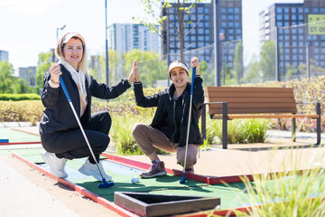 little girl and mother playing mini golf - 796314039