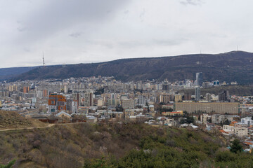 Cityscape of west part of Tbilisi, Georgia. Modern buildings. TV tower on the hill. Overcast. - obrazy, fototapety, plakaty
