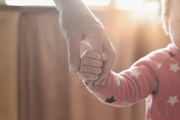 Toddler holding man´s hand, father or grandfather