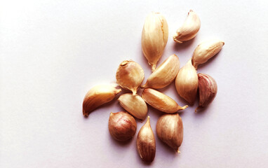  Dried garlic cloves placed on a white background.