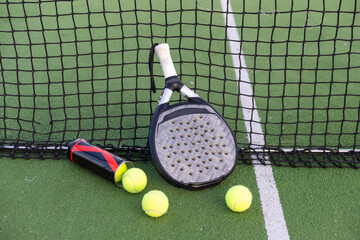 Paddle tennis racket, ball and net on the grass  - 796333253