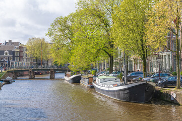 Fototapeta na wymiar House boats in a canal of Amsterdam, the Netherlands on a sunny day