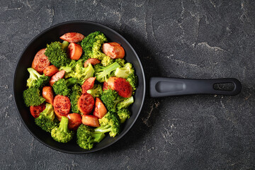 fried juicy sausage and crispy broccoli in skillet
