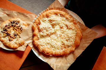 Woman hands holding langos - traditional Hungarian food