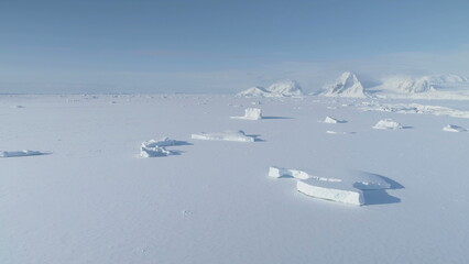 Fototapeta na wymiar Antarctica Iceberg Locked in Ice Aerial View. Arctic Polar Frozen Ocean Covered with Snow. Expedition to North Nature Landscape Coastline Glacier..
