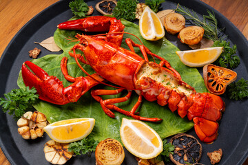 Grilled Lobster with Cheese in black wood plate, Grilled Canadian Lobster on wooden background.