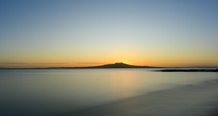 Long exposure image of Rangitoto Island at dawn. Milford Beach. Auckland.