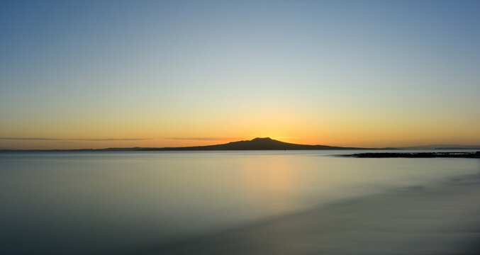 Long exposure image of Rangitoto Island at dawn. Milford Beach. Auckland.
