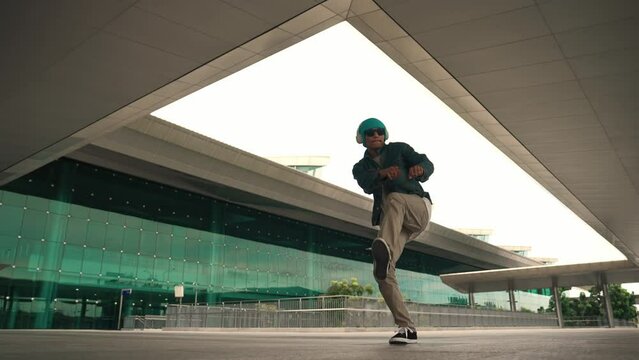 Panorama shot of happy hipster dance together while listen music from headphone at mall. Professional break dancer enjoy perform b boy footstep. Outdoor sport 2024. Modern street dancing. Sprightly.