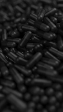 Closeup of black pills mixing and spin in slow motion with shallow DOF. Drugs, pills, tablets, medicine concept. 3d render animation. Vertical video