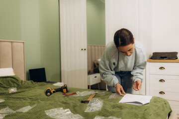 Women reading instructions to self assemble furniture in new home