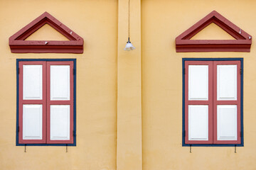 A windows with a shutter on the facade of a historic building, Thailand