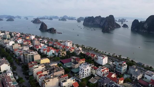 An aerial snapshot of Halong City's vibrant urban landscape, with the iconic karst formations of Halong Bay in the distance.