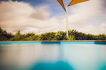swimming pool, long exposure, modern exterior, abstract, holiday vacation resort tropical, warm summer outdoors, sunny day
