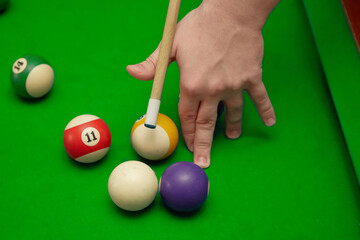 Billiard shot with a cue and balls on a billiard table, high bridge in billiards, playing “eight...