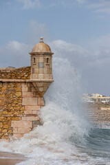 Fortress of Ponta da Bandeira gets hit by a huge wave in Lagos, Algarve, Portugal