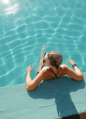 Happy woman enjoying the sun and water at the pool. Lifestyle and summer concept