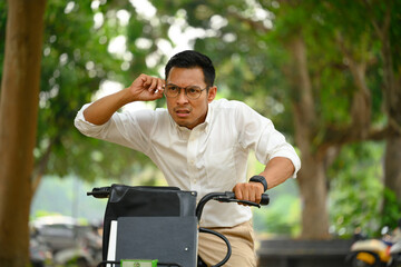 Shot o man office worker riding a bike and hurrying up at work - 796370616