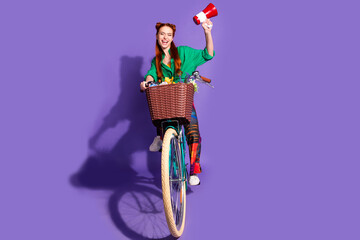 Full size photo of ecstatic woman dressed green shirt vintage pants hold loudspeaker riding bike...