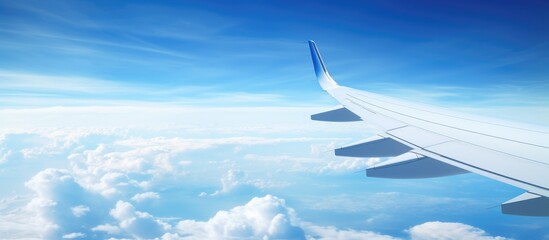 Fototapeta premium Aerial view of airplane wing soaring over clouds