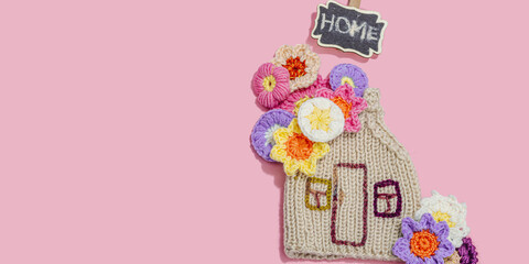 Handmade home spring decor concept. Creative crocheting, house figurine, traditional flowers
