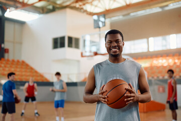 Portrait of happy black basketball player looking at camera.