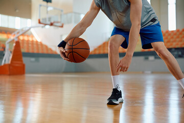 Unrecognizable basketball player in action on court.