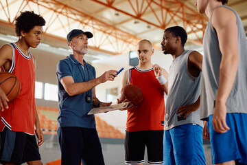 Basketball coach discussing about game plan with his players during sports training.