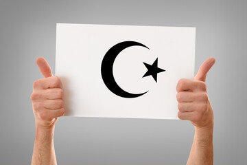 Hands okay holding a poster with islamic symbol gray isolated
