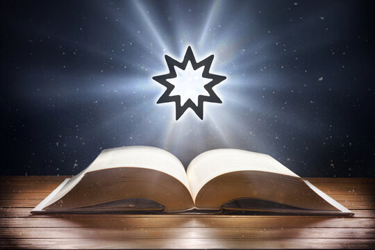Open book on wooden table and bahai symbol front view