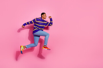 Fototapeta na wymiar Full size photo of pretty young male excited running hurry sales dressed stylish violet striped outfit isolated on pink color background