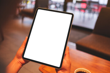 Mockup image of a woman holding digital tablet with blank white desktop screen in cafe - 796411487