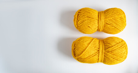 two balls of yellow thread for knitting or crocheting on a light background